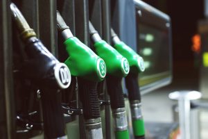 Bicos de combustível em um posto, com foco nos bicos verdes de gasolina, prontos para abastecer veículos.
